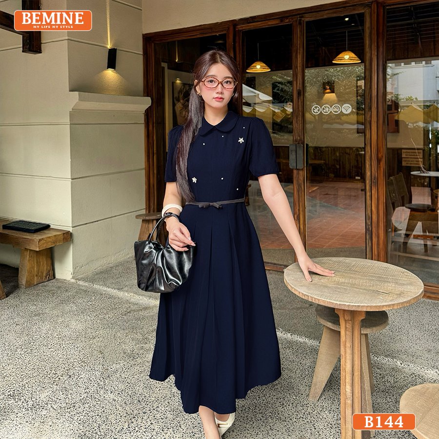 Đầm thiết kế BEMINE B144 với cổ sen duyên dáng, chi tiết đính đá lấp lánh và tùng váy xếp ly nhẹ nhàng